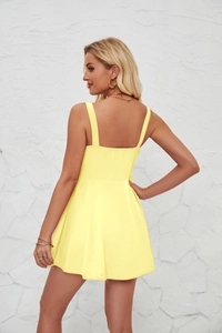 Detail view of backless yellow mini dress with tie-up straps and a minimalist A-line cut