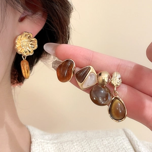 Détails de boucles d'oreilles vintage en résine aux tons ambre et accents dorés