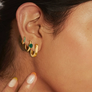 Close-up of model wearing three gold stainless steel earrings in C-shape and square designs
