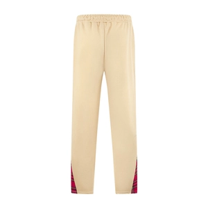 Vue détaillée du dos d'un pantalon beige avec empiècement à carreaux rouges sur les côtés