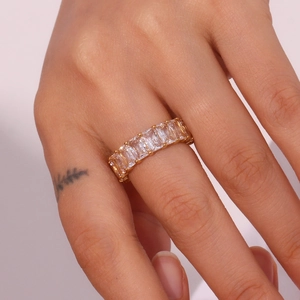 Close-up of gold plated stainless steel ring with rectangular cubic zirconia on finger