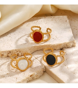 Close-up of vintage 18K gold plated oval rings with red, white and black enamel details