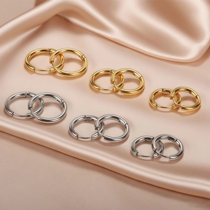 Classic gold and silver round hoop earrings set in three sizes on silk background