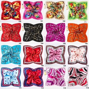 Macro view of various 50cm square silk scarfs showing diverse patterns and silky texture