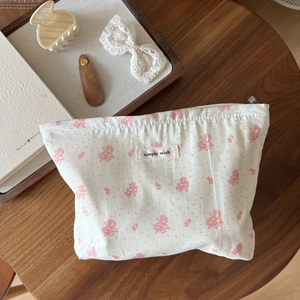 Floral cotton makeup bag with 'simple wish' label on a wooden table setup