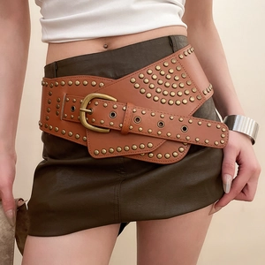 Detail of wide brown leather waist belt with vintage brass rivets and cross overlap design
