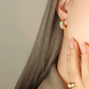 Colorful striped enamel C-shaped earrings and gold pearl ring set on female model