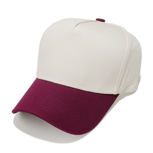 Detail view of contrast baseball cap showing beige panels and maroon brim stitching