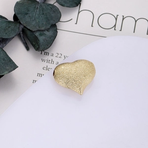 Dettaglio di un ciondolo a cuore dorato con finitura glitterata per gioielli fai-da-te