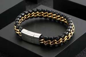 Detail of woven leather bracelet with gold stainless steel chain on a black gift box