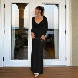 Detail of ruffle neckline and deep V-neck on a slim-fit black long-sleeve dress