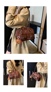 Detalle de bolso tote vintage marrón con textura de gamuza y colgante de oso de peluche