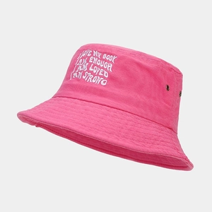 Détail d'un bob en coton rose avec broderie blanche et œillets d'aération