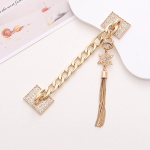 Close-up of a gold zinc alloy phone strap featuring rhinestones and a metal tassel