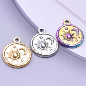 Macro shot of sun moon and star engraved charms in gold silver and rainbow steel