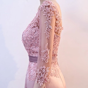 Close-up of pink lace evening gown with floral embroidery and hand-sewn pearls