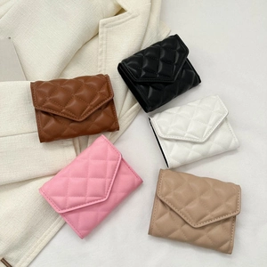 Quilted faux leather mini wallets in five colors on beige suit background
