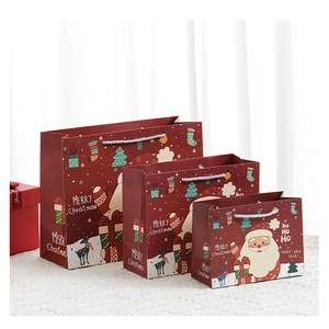 Various sizes of red Christmas gift bags with Santa Claus prints and woven handles