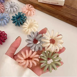 Close-up of elastic jelly color spiral hair ties held in hand with assorted bright colors