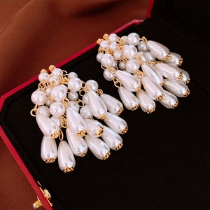 Boucles d'oreilles pendantes avec perles et cristaux sur une boîte de luxe rouge