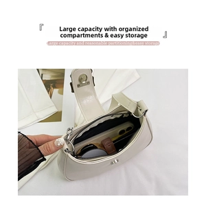 Spacious interior of off-white half-moon shoulder bag with bow and chain detail