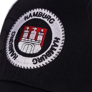 Close-up of the detailed Hamburg coat of arms embroidery on black cotton baseball cap