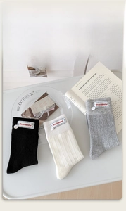 Detail of ribbed knit cotton socks in grey and off-white with fabric brand labels
