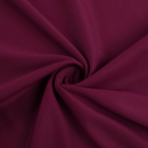 Vue macro du tissu de robe bordeaux foncé montrant la texture lisse et l'éclat