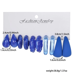 Detail showing Klein blue earring set including C-shape hoops and teardrop resin studs