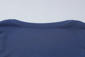 Gros plan sur l'encolure carrée et la texture en maille côtelée du haut moulant bleu foncé