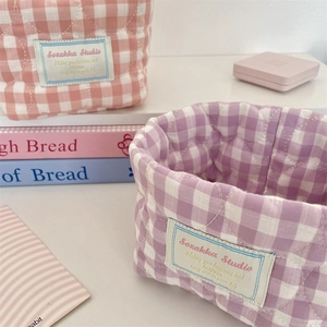 Detailed view of quilted cotton storage baskets with heart stitching and woven label detail