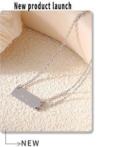 Macro view of silver rectangular pendant with chic engraving on a textured sandy surface