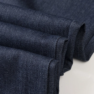 Gros plan sur la texture du denim bleu foncé montrant le tissage sergé et la qualité du tissu