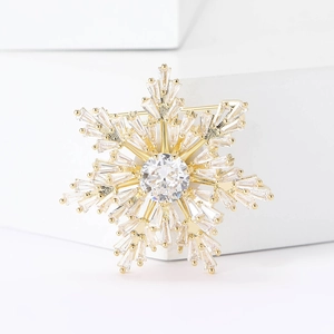 Macro shot of snowflake brooch with gold finish and sparkling crystal zircons