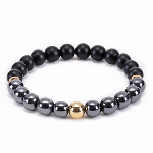 Elastic beaded bracelet with matte black lava stones and hematite beads on white backdrop