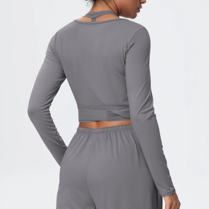 Detail of cross-straps on the back of a charcoal grey cropped long-sleeve fitness top