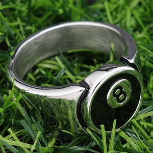 Close-up of vintage stainless steel number 8 billiard ring on green grass background