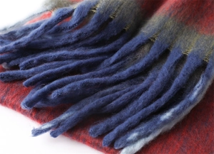 Close-up of red and blue cashmere-like scarf showing thick knit texture and long fringe