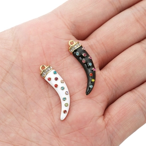 Enamel horn pendant necklace with white zircons and colorful rhinestones in hand