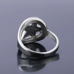 Macro detail of silver stainless steel star ring showing brushed finish and inner band