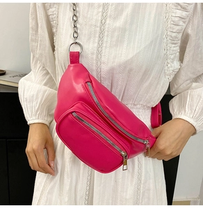 Detail of fuchsia leather crossbody waist bag with silver chain strap and dual zippers