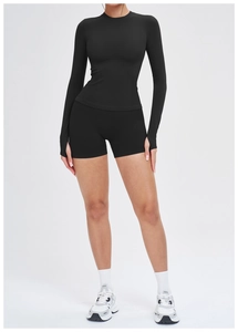 Détail d'un ensemble de yoga noir sans couture avec haut à manches longues et short taille haute
