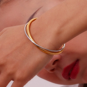 Detailed view of interconnected gold and silver polished rings on a model wrist