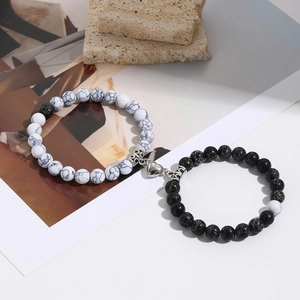 Detail of magnetic heart clasp connecting black and white marble beaded couple bracelets
