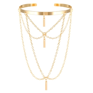 Close-up of gold layered chain armlet with rectangular charms and polished metal finish