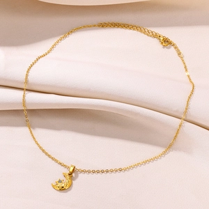 Detail of 18K gold star and moon pendant with cubic zirconia on elegant satin background