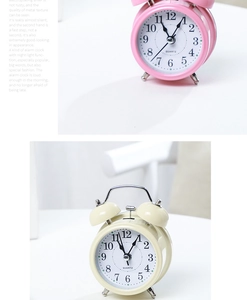 Detail of pink and beige metal twin bell alarm clocks with quiet quartz movement
