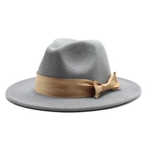 Side view detail of a classic grey felt fedora hat with a tan satin bow band.