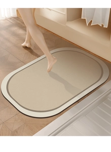 Close-up of oval diatom mud bath mat on wooden floor with bare feet for drying demo