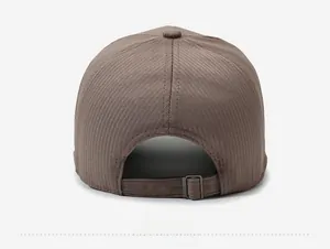 Detail view of the brown corduroy baseball cap back featuring an adjustable metal strap